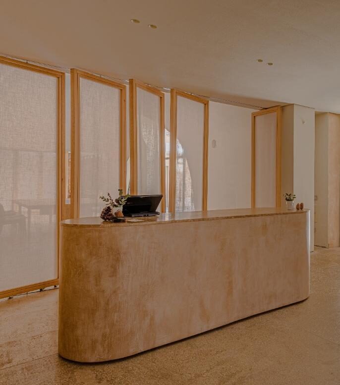 Sobre recepción en Marrón Emperador, lavabo macizo en Calacatta y aplacado baño en Verde Borgogna.