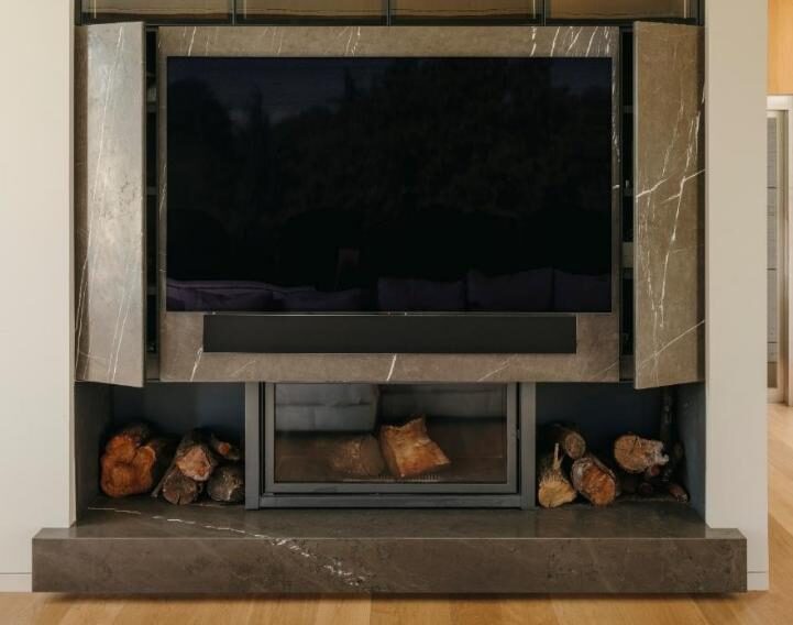 Mesa en Calacatta Gold, chimenea en Grey Stone y barra en Cuarzo.