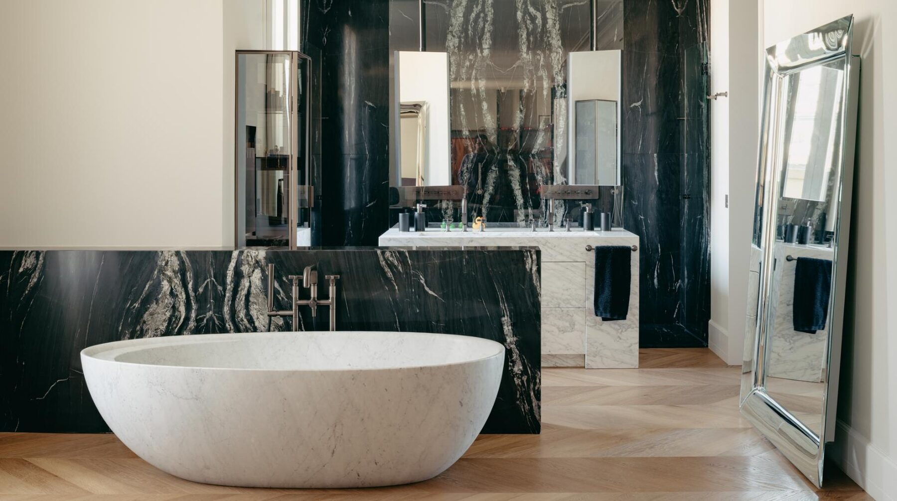 Aplacados y plato de ducha en cuarcita Belvedere. Mueble en mármol Carrara, interior en roble.